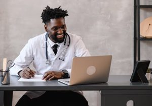 doctor on laptop helps patient register for virtual healthcare