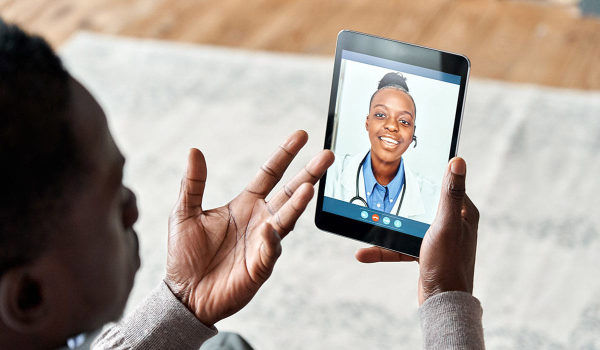 a person holding a tablet with a doctor on the screen