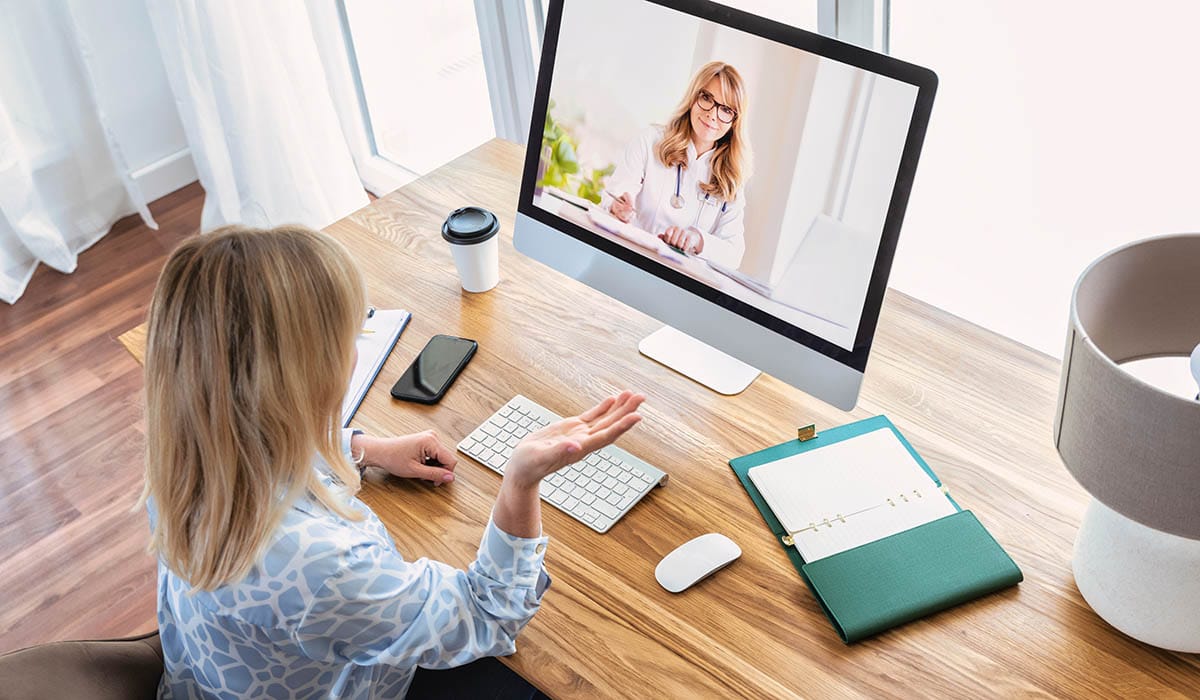 a woman sitting at a desk with a computer