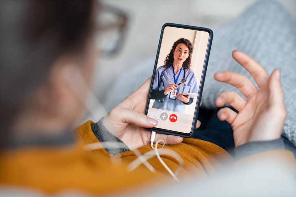 person looking at phone and talking to doctor about getting a second opinion on surgery
