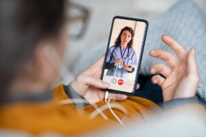 person looking at phone and talking to doctor about getting a second opinion on surgery