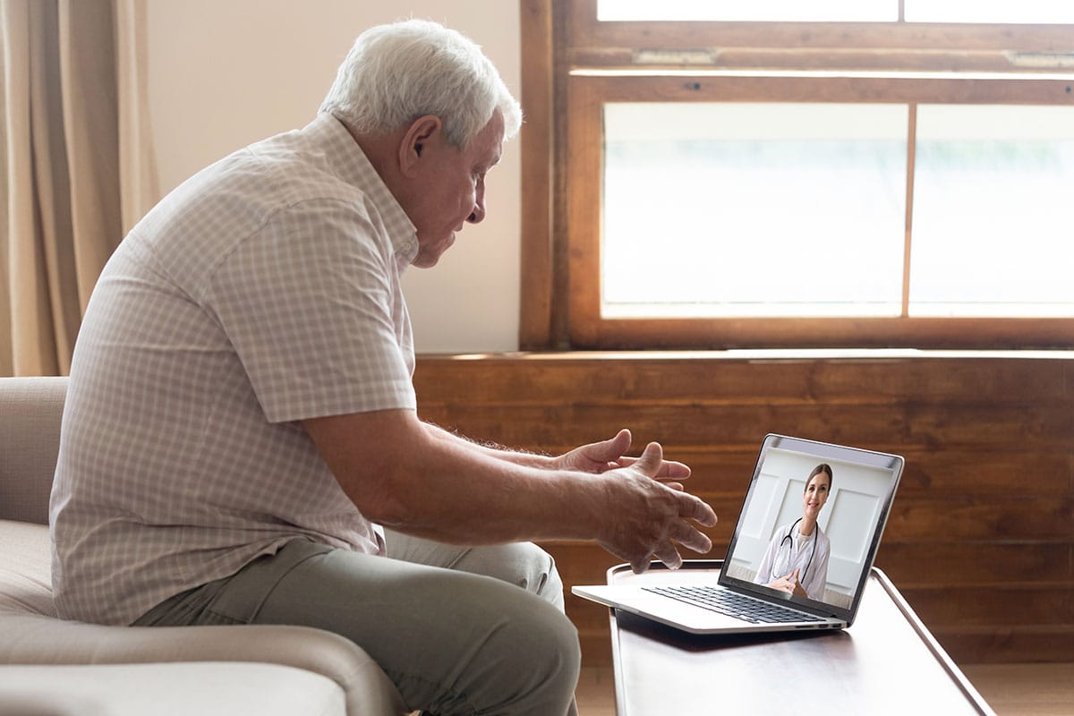 man talks to doctor on laptop about a second opinion after knee surgery