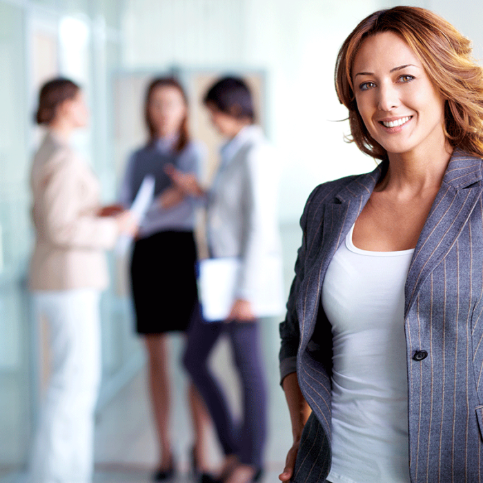 woman in blazer with colleagues talking about how to improve employee health