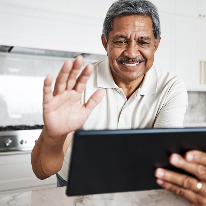 a man waving at a tablet