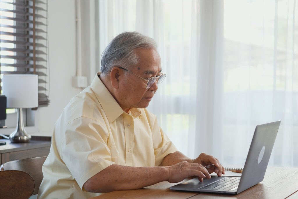 an old man using a laptop