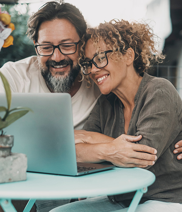 a man and woman looking at a laptop