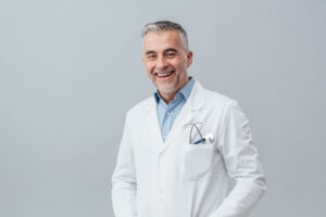 A doctor is smiling at the camera. He's ready to give a virtual second opinion to senior parents.
