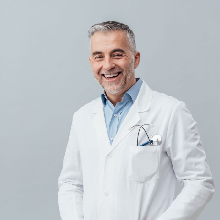A doctor is smiling at the camera. He's ready to give a virtual second opinion to senior parents.